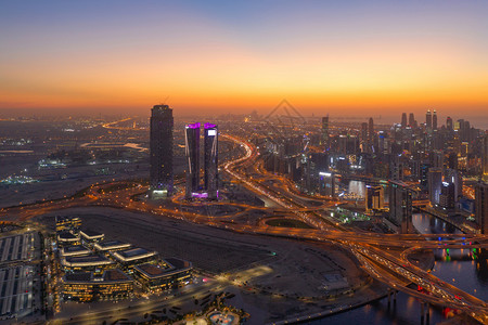 迪拜下城天线和高速公路阿拉伯联合酋长国或阿金融区和智能城市商业区的空中观察夜里有天梯和高楼大图片