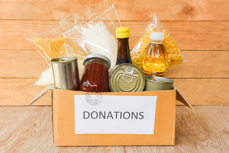 木桌背景的罐装食品和的捐赠箱罐装食品和干用油饭面条意大利通心粉捐赠食品概念不可腐烂图片