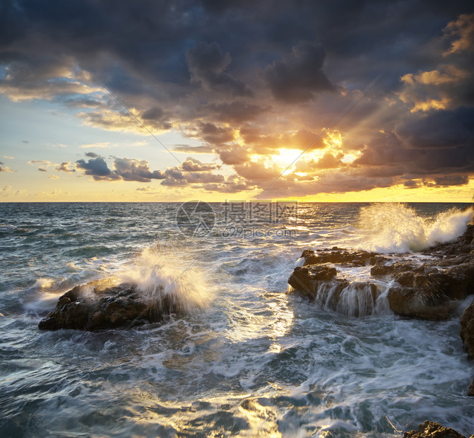 美丽的海景暴风雨中的海浪日落时会喷洒到石头上自然的构成图片