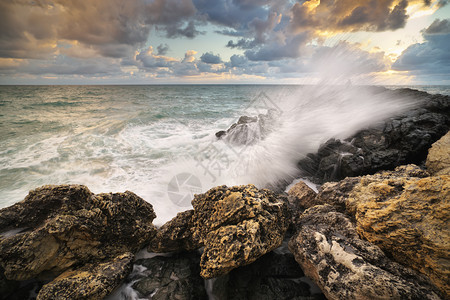 美丽的海景暴风雨中的海浪日落时会喷洒到石头上自然的构成图片