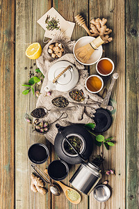 各种茶叶和壶成分干草药绿色黑茶和木制桌底的红茶平铺背景图片