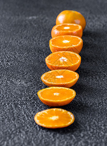 黑色背景的新鲜半熟橘子图片