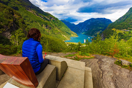 旅游度假和行从Flydalsjuvet的观点看在神奇的Geirangerfjorden上景色美丽的女游客挪威旅景点图片