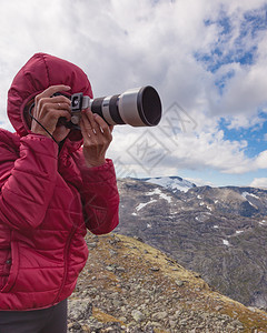 女游客用照相机享受来自挪威Dalsnibba地区的山风景图片