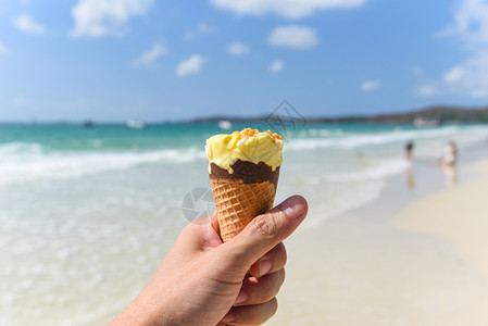 夏季天气炎热的海滩上融冰淇淋海洋景观自然户外度假黄冰淇淋芒果与坚冰淇淋锥与海背景齐头并进图片