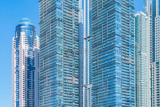 玻璃建筑的外观设计在城市迪拜中心城财政区和蓝天进行反射图片