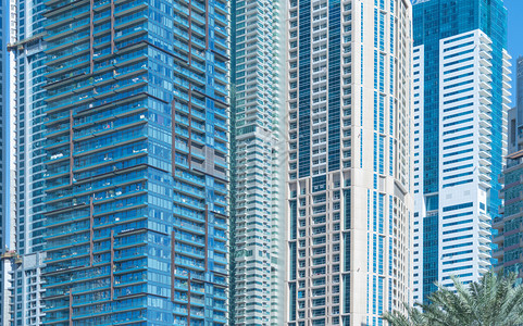 玻璃建筑的外观设计在城市迪拜中心城财政区和蓝天进行反射图片