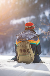 美丽的高加索女孩正坐在雪中冬季风景奥地利图片