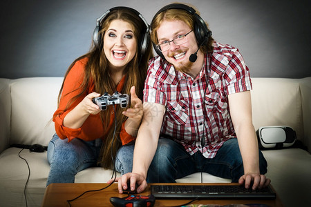 快乐的情侣通过一起玩电子游戏享受休闲时间图片