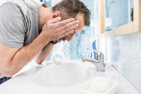 男人在脸上泼水洗澡照顾个人卫生清晨感觉新在浴室洗脸图片