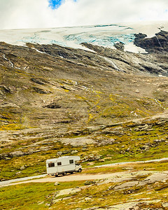 在挪威群山公路上的旅游度假露营房车图片