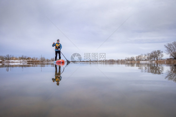 在科罗拉多州初春一名高级男护甲手站在桨板上科罗拉多州一名高级男护甲手在幼年春起踏板上图片