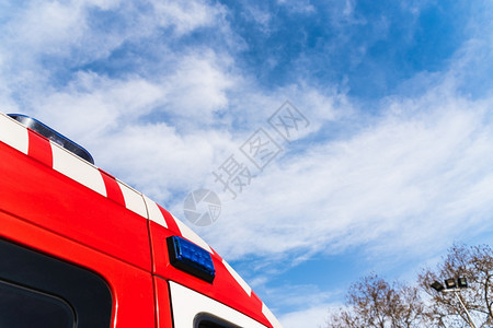 一辆医疗救护车的红色屋顶覆盖蓝天上面有云和复制空间以照顾流行病患者图片