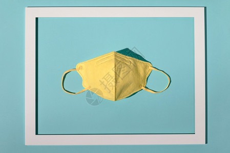 新冠概念构成由黄色面罩和白框组成以亮蓝色背景创用最小概念平底图片