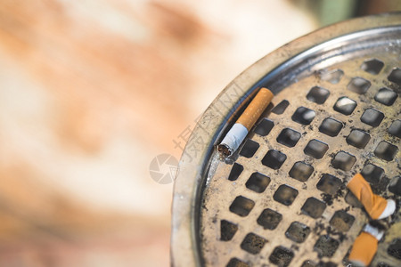 被香烟污染肺在公共烟灰缸中关闭香极端关闭有选择地聚焦背景