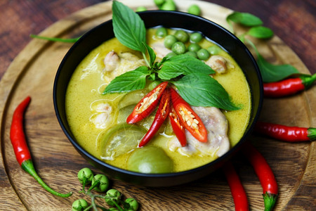 汤碗上泰国菜绿色咖喱配有木板背景绿咖喱鸡烹饪和桌上的饭菜图片