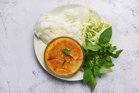 汤背景餐桌上的红咖哩菜泰国咖哩汤碗白盘上加茶米面成品蔬菜背景