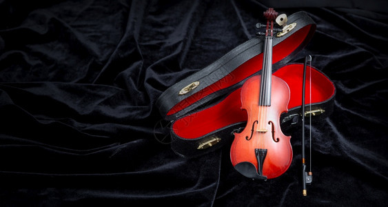 带小提琴的在黑暗的天鹅绒上放一个小提琴有复制空间图片