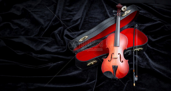 带小提琴的在黑暗的天鹅绒上放一个小提琴有复制空间图片