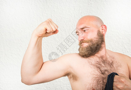 一个留胡子的男展示他手臂肌肉图片
