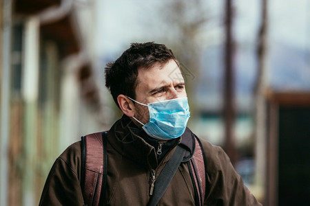 在户外的年轻人戴着面罩科罗纳和流感季节图片