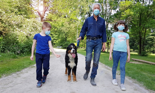 爷和孙子在科罗纳期间和狗一起在公园里散步图片