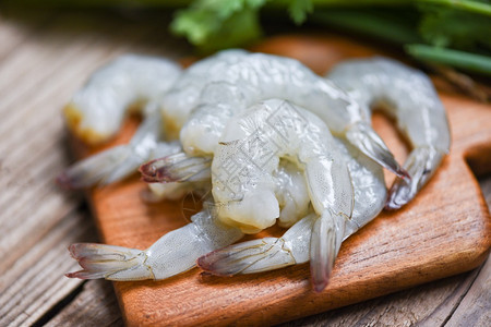 木制切削板上生虾烹饪关闭新鲜虾或海产食品架的背景图片