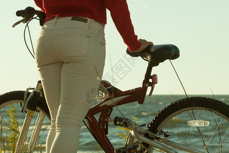 自行车海在海滩上骑自行车的女人背影背景