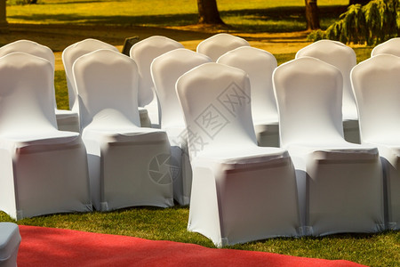 许多张白色优雅封面的婚礼椅子绿色草地上有许多张白色优雅封面的婚礼椅子门外拍摄图片