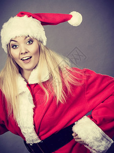 穿着圣诞老人帮手服装的快乐妇女奔跑在某个地方图片