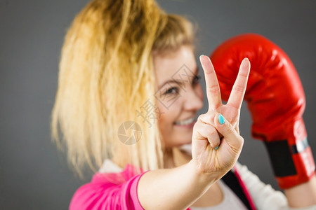 身着红拳击手套的运动快乐妇女表现出积极的姿态和平图片