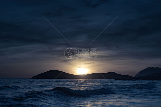 日落在海面上边风景西班牙穆尔亚岛卡塔赫纳尔布兰克自然公园西班牙卡尔布兰克海滩图片