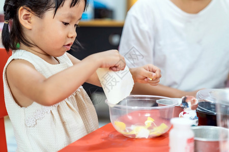 亚洲女孩玩具和彩色纸在家里客厅上艺术课在家里上学而城市封锁是因为世界各地以四胞胎妈为老师图片