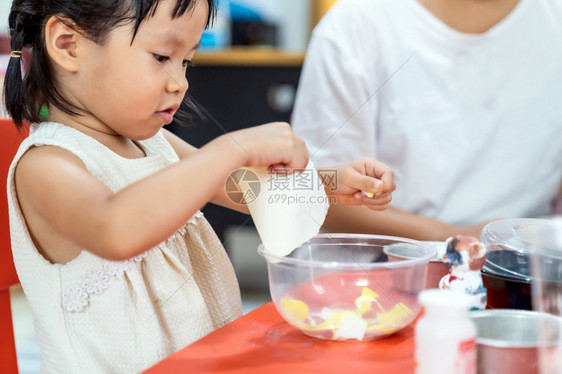 亚洲女孩玩具和彩色纸在家里客厅上艺术课在家里上学而城市封锁是因为世界各地以四胞胎妈为老师图片