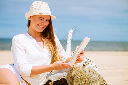 长的发美女在沙滩上戴着平板电子书的草帽女学生暑假在新鲜空气中休息女学生在海边有平板图片