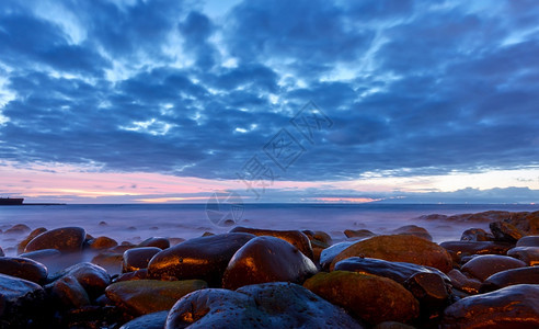 日落之后的海和边有大石头的滩风景黄光的海特纳里夫卡图片