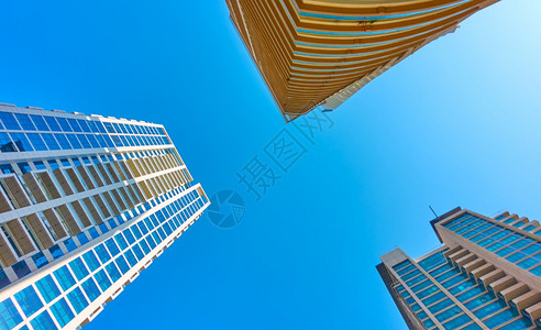 现代许多储存的公寓大楼对清蓝天空的瞄准镜头图片