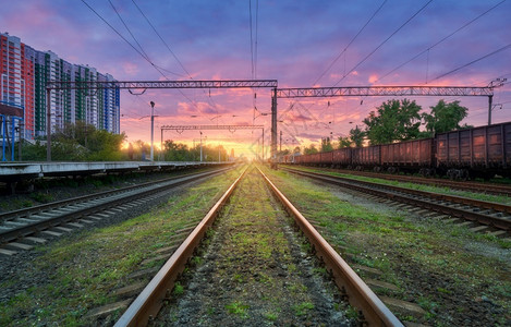 火车站列日落多彩夏季铁路重工业火车绿色草铁路平台紫色天空粉云层运输图片
