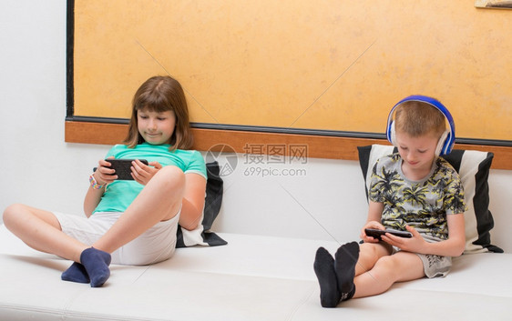 姐和哥在家用智能手机玩网上游戏图片