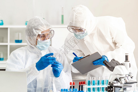 科学家在实验室检查罗纳共19大流行的疫苗测试科学家穿戴个人防护服和医疗目镜科学技术和保健概念图片