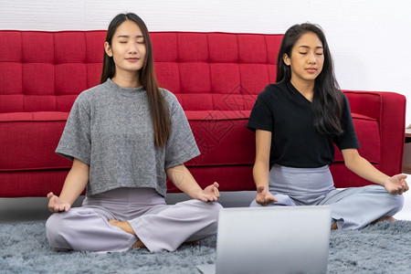 两位女从网上冥想辅导中进行思考以放松并减少压力与图片