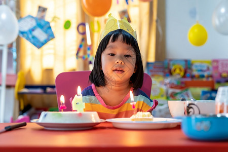 亚裔女孩带着生日蛋糕独自与家人庆祝图片