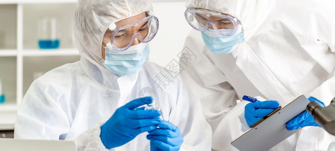 全景科学家在实验室检查罗纳共19大流行的疫苗测试科学家穿戴个人防护服和医疗目镜学和保健概念图片
