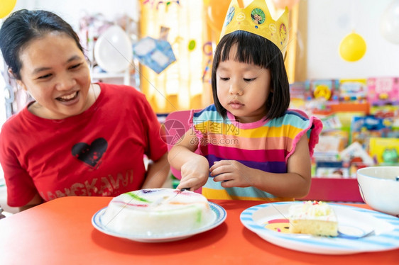亚洲女孩独自和妈一起庆祝生日蛋糕因为城市被封锁而新冠19大流行疾病图片