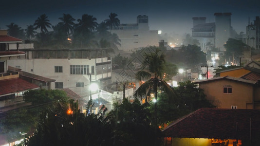 热带季节降雨夜间在岛上的亚述城市进行热带季节降雨夜间在异国岛屿上的亚述城市进行图片