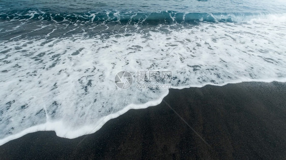 蓝色海浪以黑火山沙子在海滩上滚动和破碎的美丽图像蓝色海浪以黑火山沙子在海滩上滚动和破碎的美丽图像图片