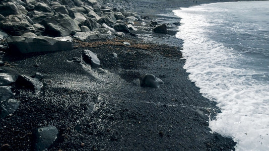 火山海滩上黑色岩石和悬崖的景观图片