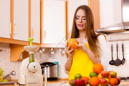 厨房的年轻女家庭主妇配有水果和汁准备新鲜健康饮食烹饪素饮和人的概念图片