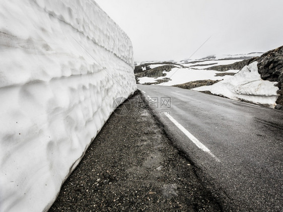 挪威奥兰和莱尔达之间的高雪墙和山路奥兰登风夏季挪威奥兰和莱尔达之间的奥兰登风山路图片