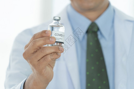 医生手持药瓶在实验室或进行化白底隔离以诊断医学和冠状或covid19概念中的疾病图片